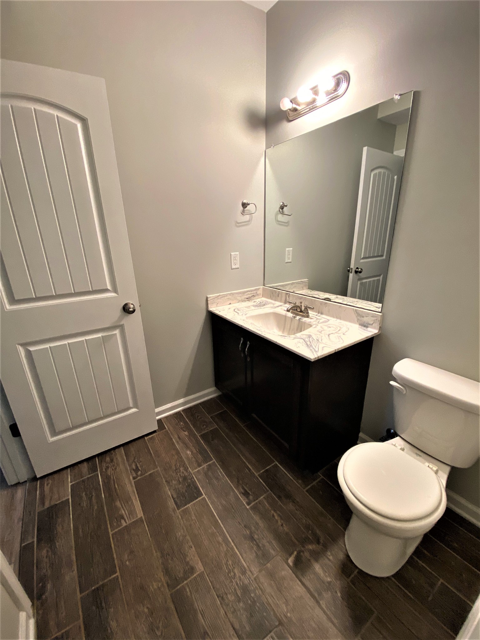 4200 Station Road Cunningham, TN 37052 - Photo 25 of 37 a bathroom with a granite countertop sink toilet a mirror and vanity