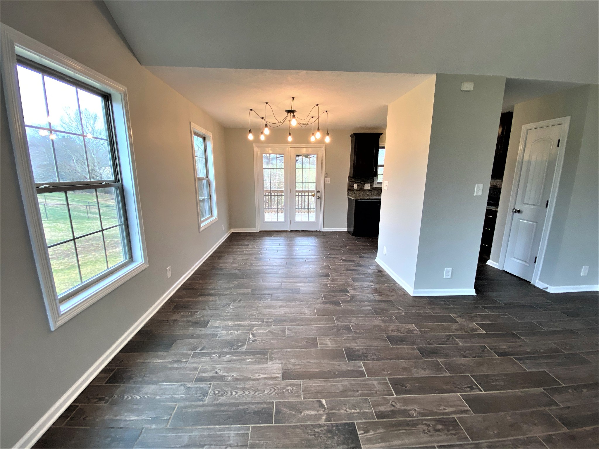 4200 Station Road Cunningham, TN 37052 - Photo 5 of 37 an empty room with large windows and wooden floor