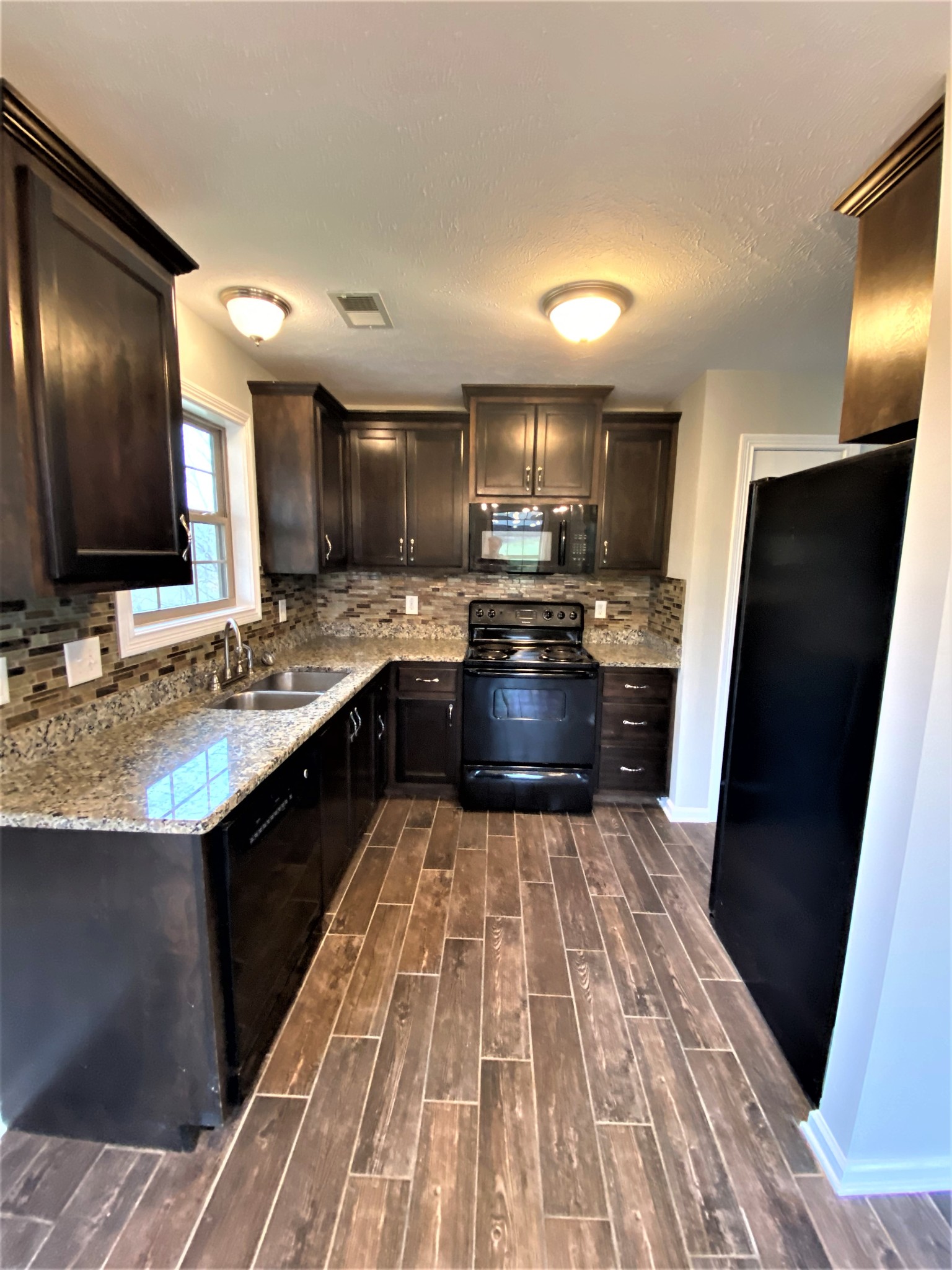 4200 Station Road Cunningham, TN 37052 - Photo 7 of 37 a kitchen with stainless steel appliances granite countertop a sink stove and refrigerator