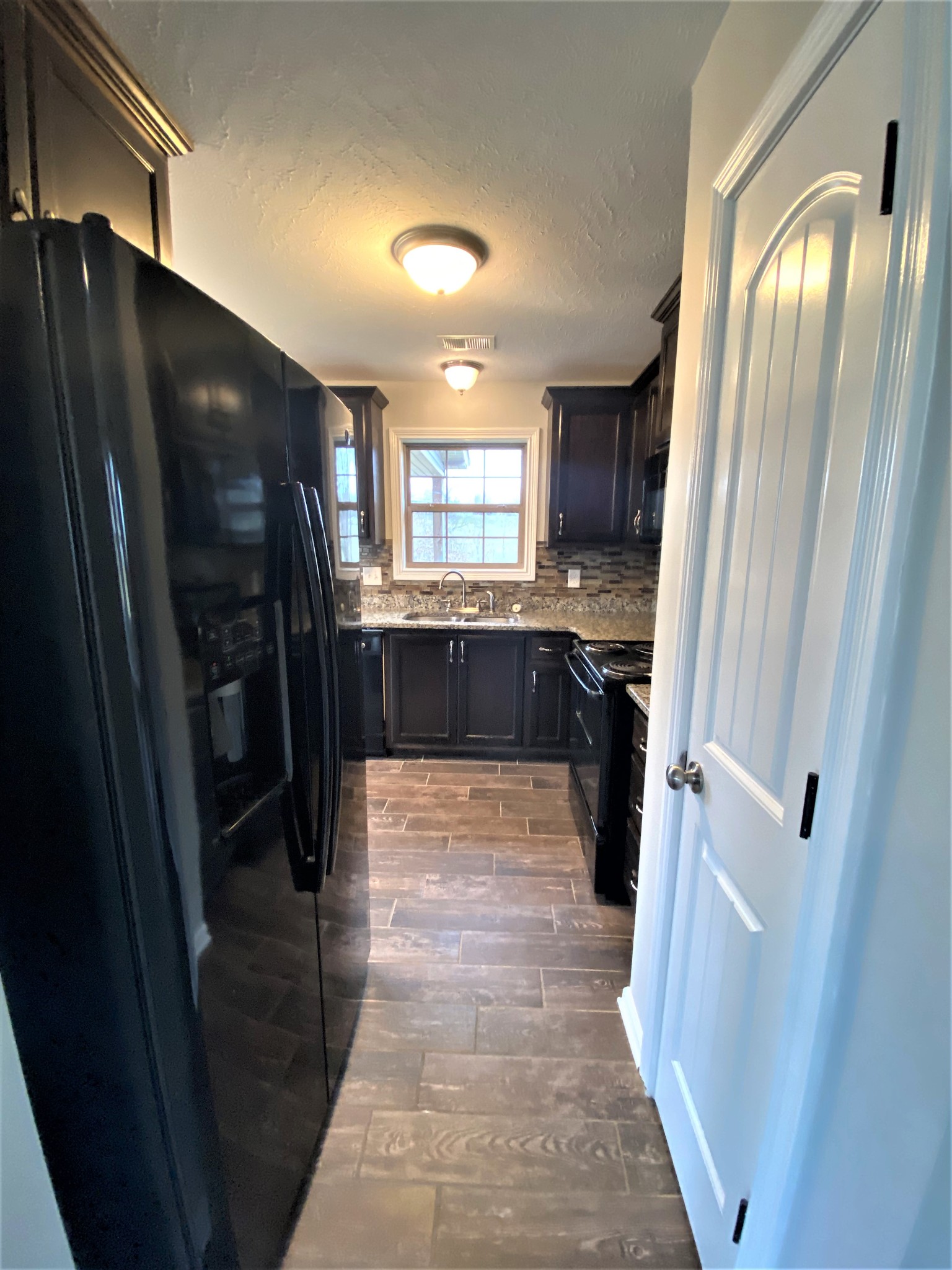 4200 Station Road Cunningham, TN 37052 - Photo 8 of 37 a kitchen with stainless steel appliances a refrigerator and a sink
