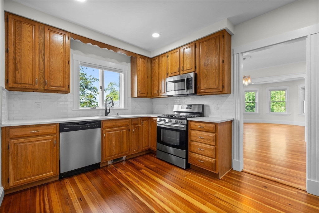 37 Fountain Road, Unit 2 Arlington, MA 02476 - Photo 7 of 25 a kitchen with stainless steel appliances granite countertop wooden cabinets a stove a sink and a microwave