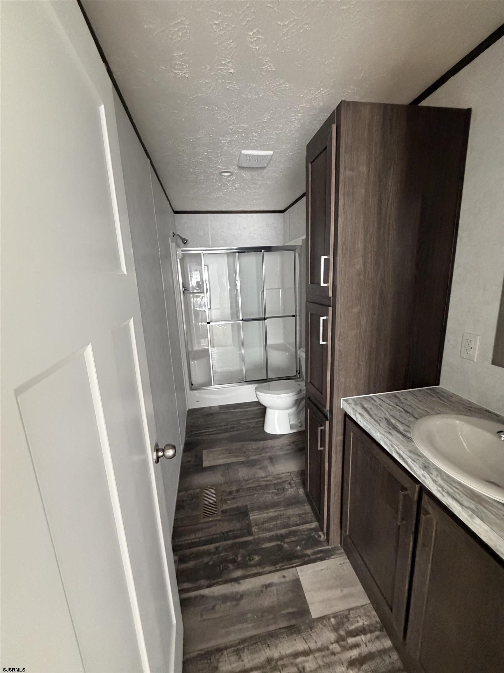 433 Poplar Road Laurel Lake, NJ 08332 - Photo 2 of 12 a bathroom with a sink and mirror with bathtub
