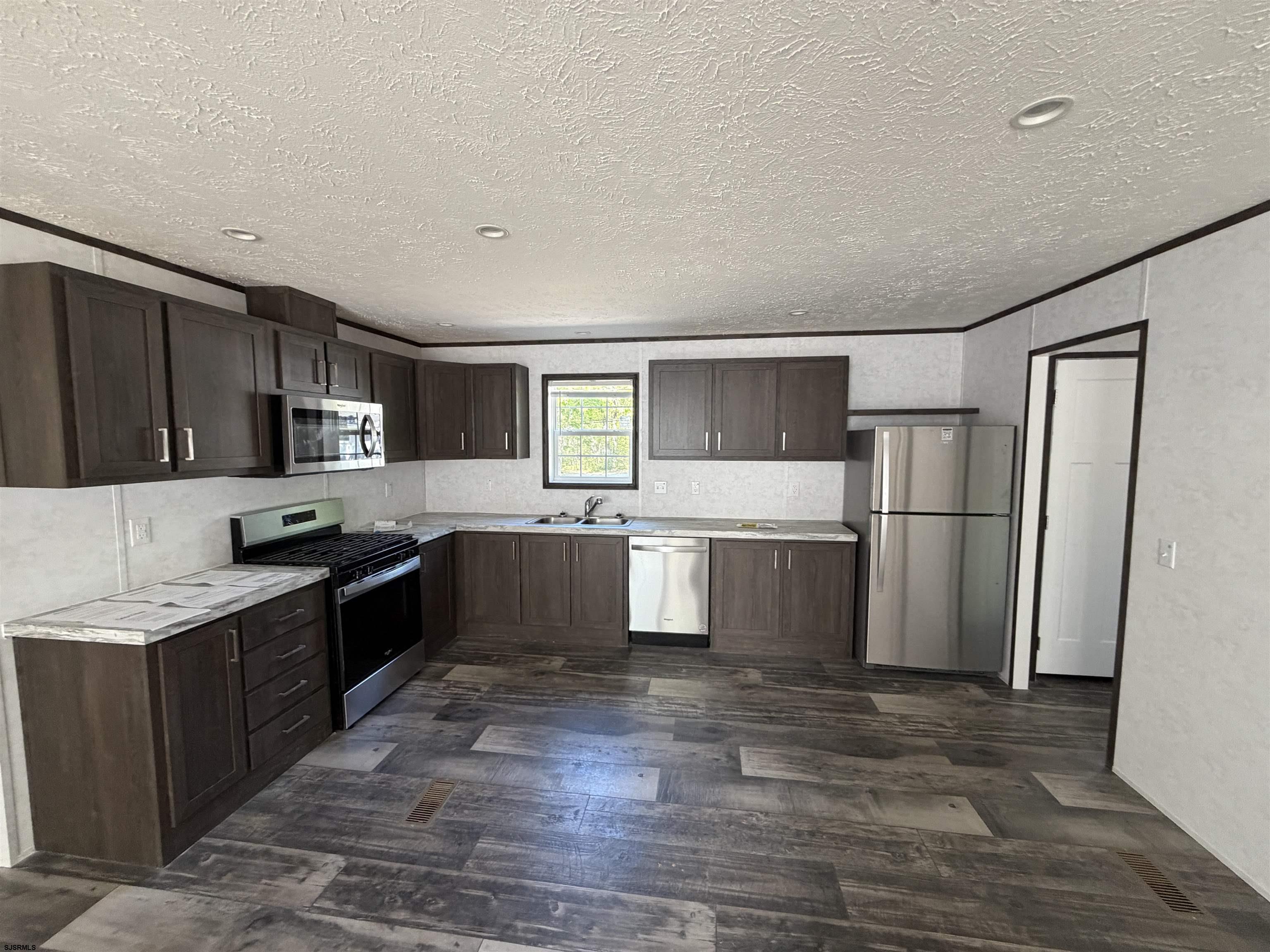 433 Poplar Road Laurel Lake, NJ 08332 - Photo 7 of 12 a kitchen with stainless steel appliances kitchen island granite countertop a refrigerator a sink dishwasher a stove top oven a refrigerator with wooden floors and cabinets