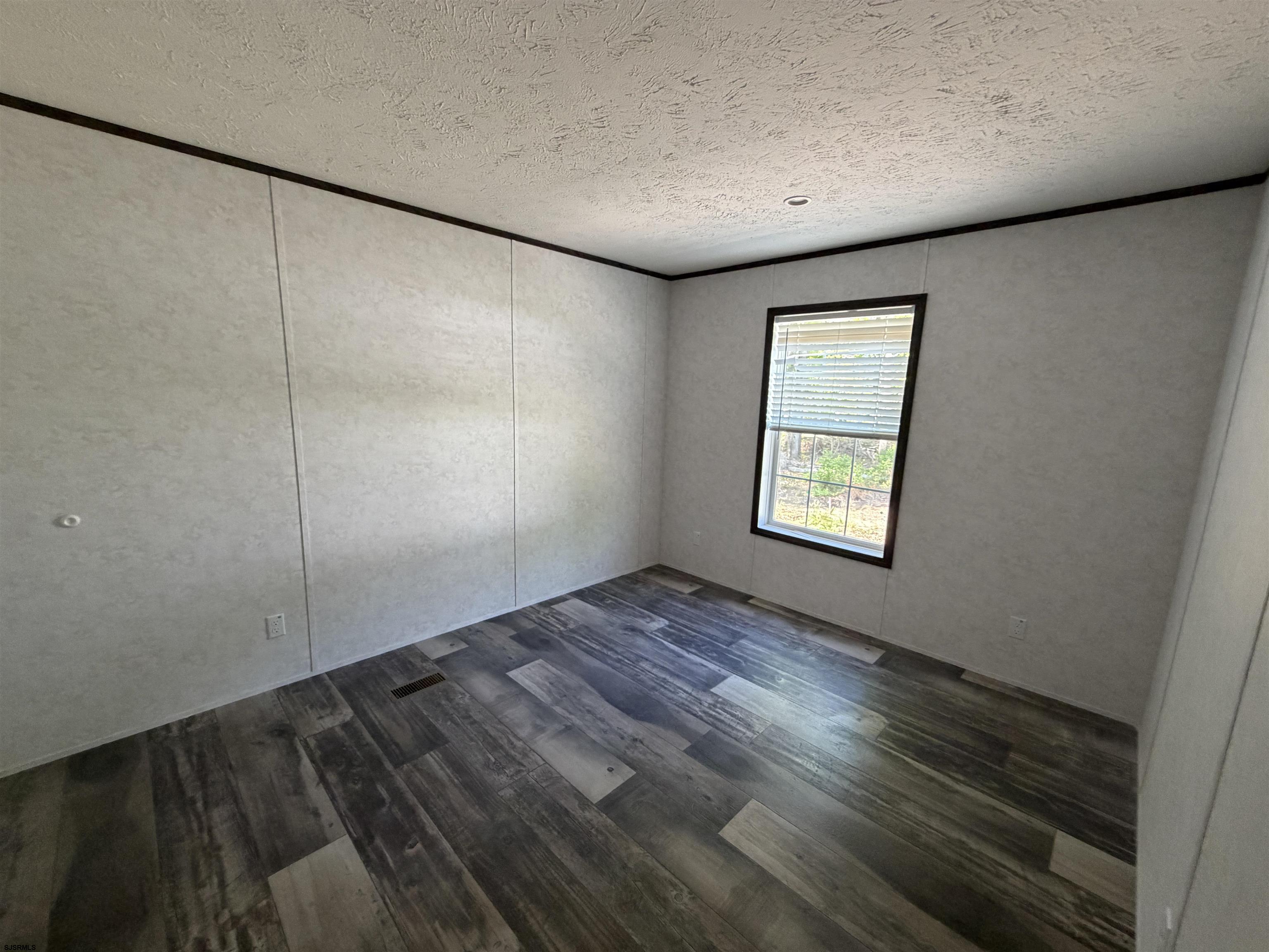 433 Poplar Road Laurel Lake, NJ 08332 - Photo 9 of 12 an empty room with wooden floor and windows