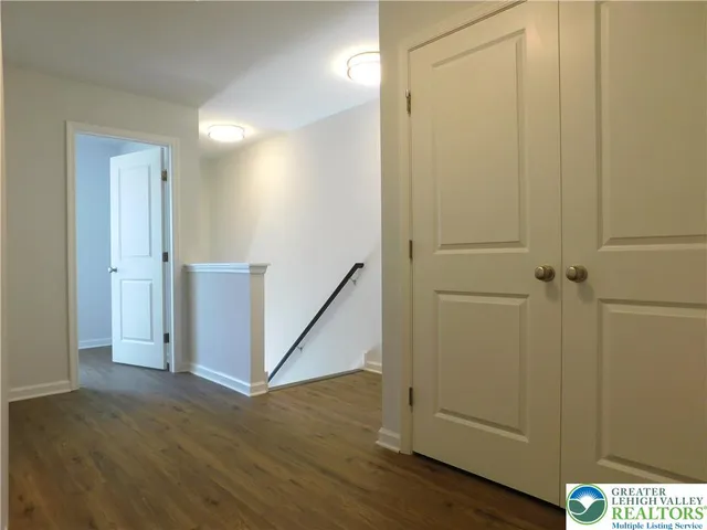 an empty room with wooden floor and entrance