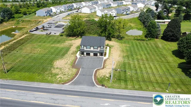 an aerial view of a residential houses with yard