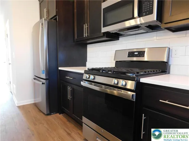 a kitchen with granite countertop a stove and a microwave