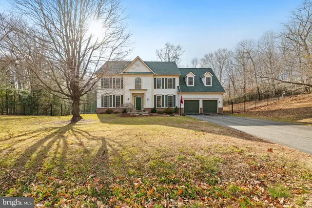 a front view of a house with a yard covered with snow