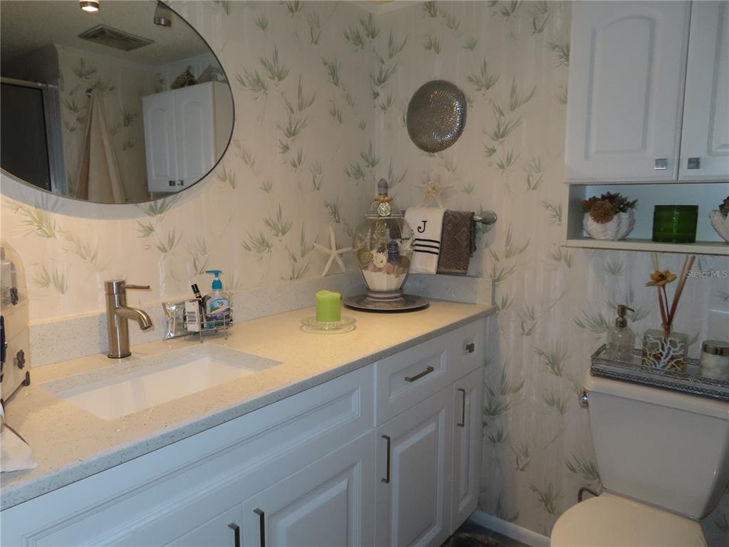 225 Country Club Drive, Unit C225 Largo, FL 33771 - Photo 13 of 26 a bathroom with a sink mirror and vanity