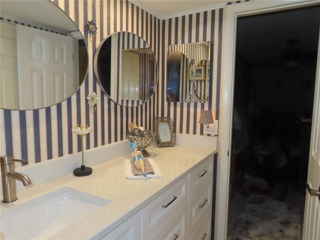 225 Country Club Drive, Unit C225 Largo, FL 33771 - Photo 16 of 26 a bathroom with a sink and a mirror