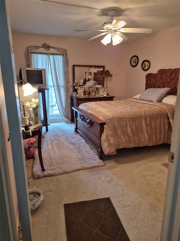 225 Country Club Drive, Unit C225 Largo, FL 33771 - Photo 24 of 26 a spacious bedroom with a bed and a chandelier