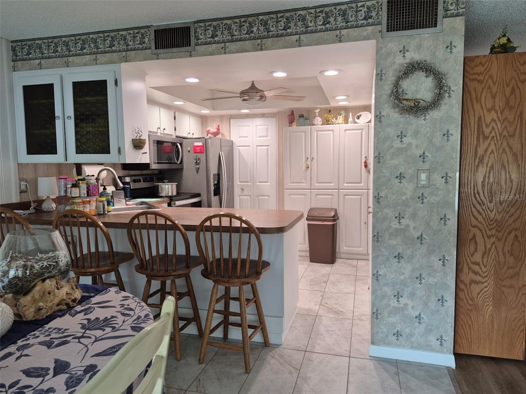 225 Country Club Drive, Unit C225 Largo, FL 33771 - Photo 9 of 26 a dining room with furniture and a chandelier