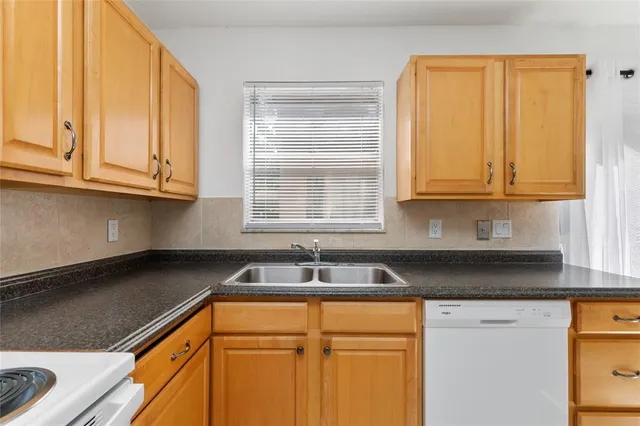 a kitchen with granite countertop cabinets sink and window