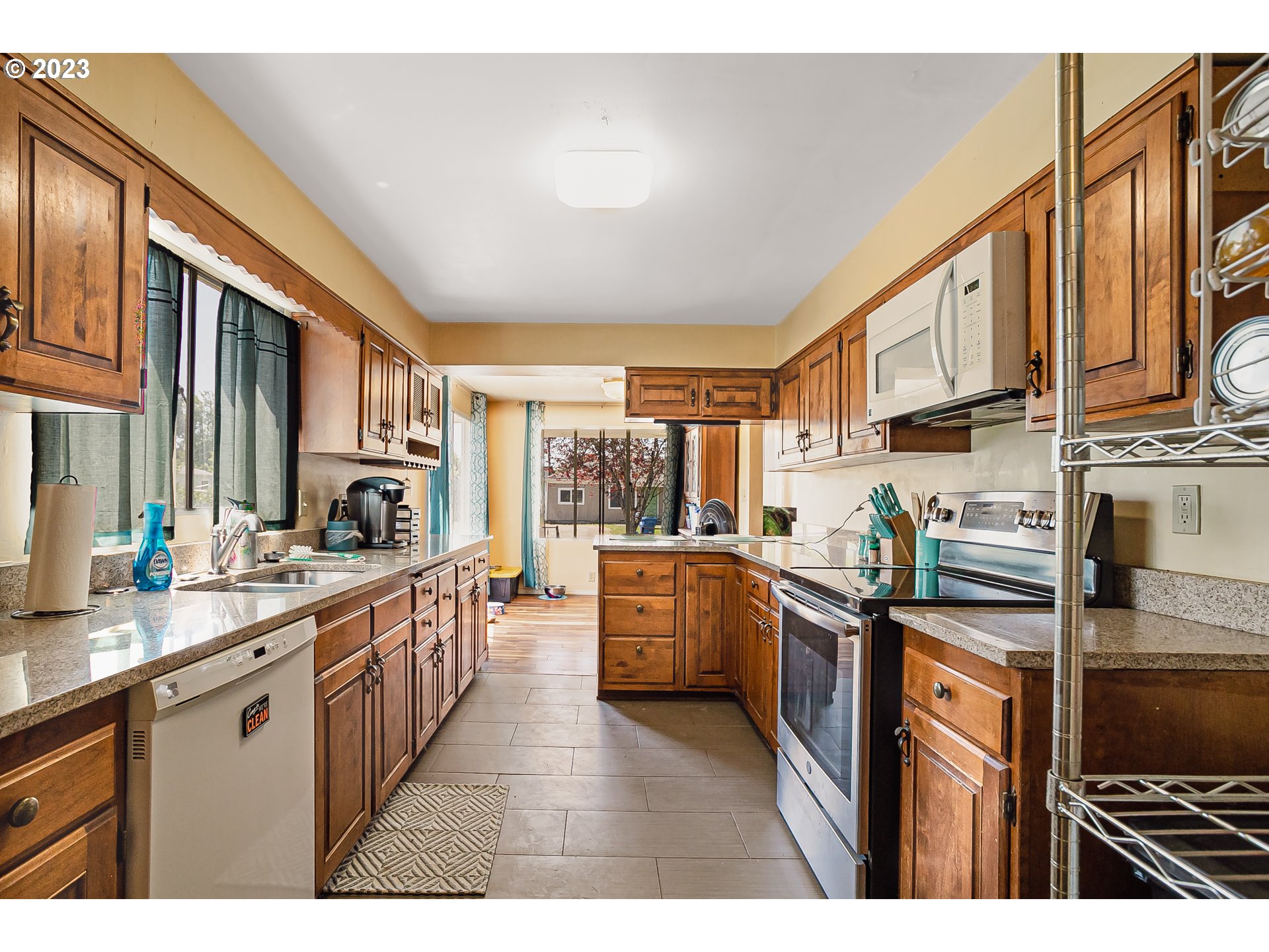 465 North 24th Street Springfield, OR 97477 - Photo 11 of 30 a kitchen with stainless steel appliances granite countertop a stove a sink dishwasher and cabinets with wooden floor