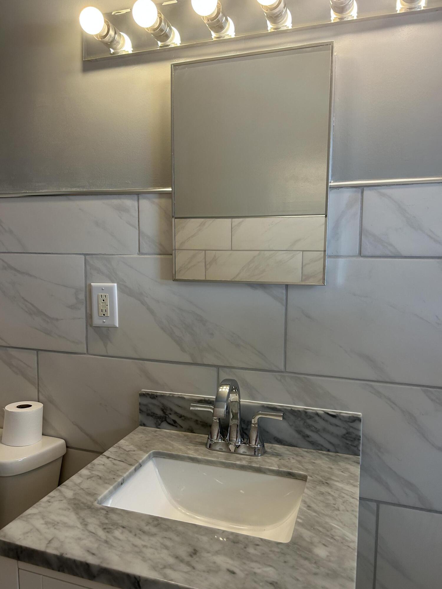 3679 Monroe Street Gary, IN 46408 - Photo 13 of 23 a bathroom with a sink and a mirror