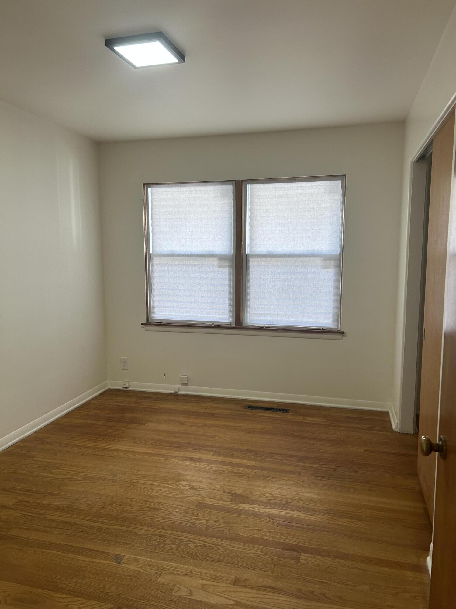3679 Monroe Street Gary, IN 46408 - Photo 14 of 23 an empty room with wooden floor and windows