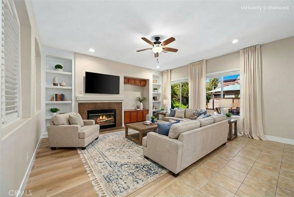 26764 Kingwood Road Murrieta, CA 92563 - Photo 12 of 42 a living room with furniture a fireplace and a flat screen tv