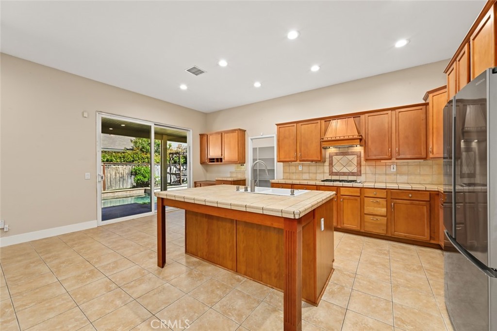 26764 Kingwood Road Murrieta, CA 92563 - Photo 16 of 42 a kitchen with stainless steel appliances granite countertop a stove a sink and a refrigerator