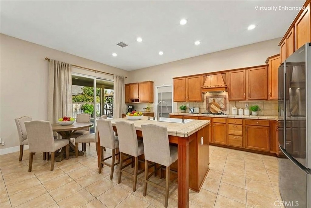 26764 Kingwood Road Murrieta, CA 92563 - Photo 17 of 42 a dining hall with stainless steel appliances a table and chairs
