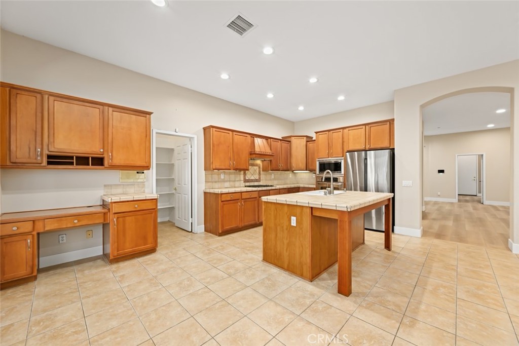26764 Kingwood Road Murrieta, CA 92563 - Photo 18 of 42 a open kitchen with stainless steel appliances granite countertop a stove top oven a sink dishwasher and a refrigerator