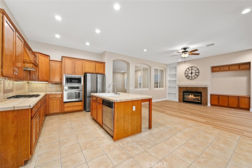 26764 Kingwood Road Murrieta, CA 92563 - Photo 19 of 42 a large kitchen with stainless steel appliances granite countertop a stove and a sink