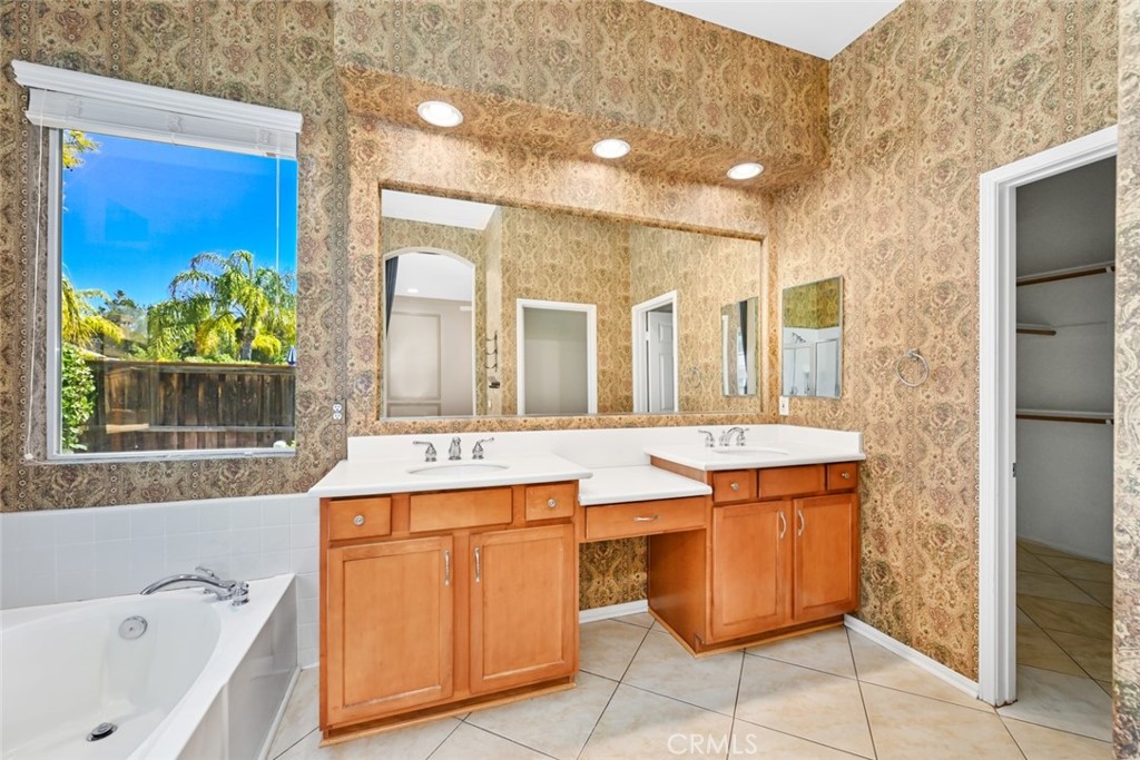 26764 Kingwood Road Murrieta, CA 92563 - Photo 25 of 42 a bathroom with a tub sink and mirror
