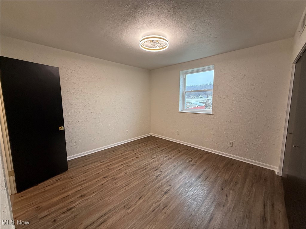 522 North 3rd Street Toronto, OH 43964 - Photo 27 of 47 Unfurnished bedroom featuring a textured wall, a textured ceiling, and dark wood-style flooring