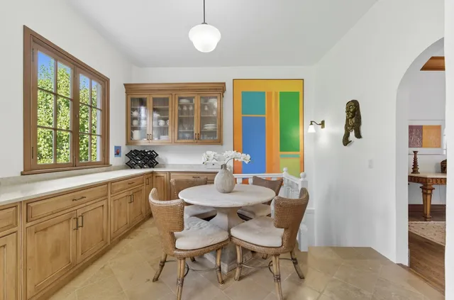 a bedroom with a large bed a chandelier and a window