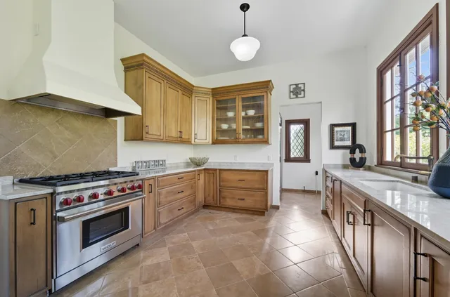 a kitchen with stainless steel appliances granite countertop a dining table and chairs with wooden floor