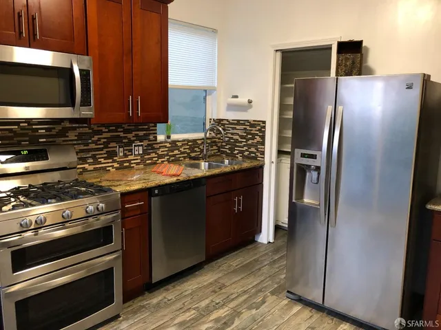 a kitchen with stainless steel appliances granite countertop a refrigerator stove and microwave