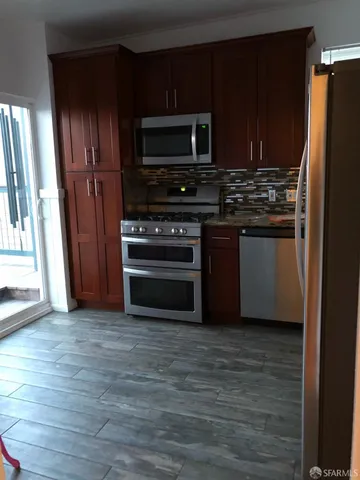 a kitchen with stainless steel appliances and wooden cabinets