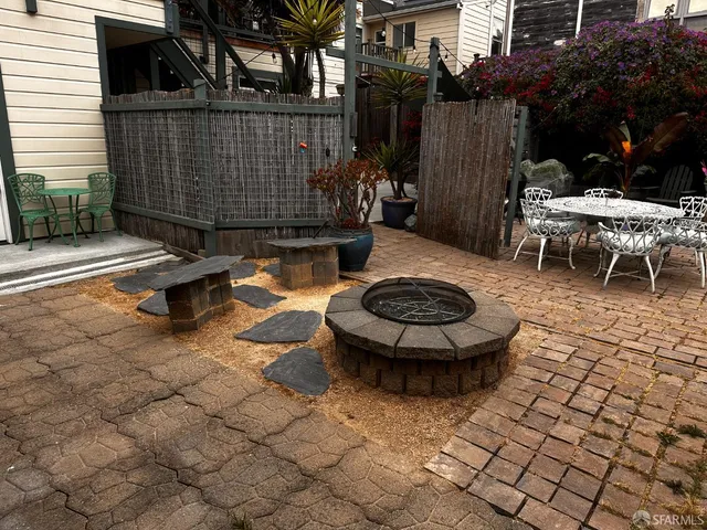 a view of a chair and tables in backyard of the house