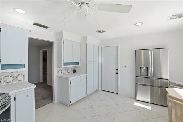 a kitchen with white cabinets and refrigerator