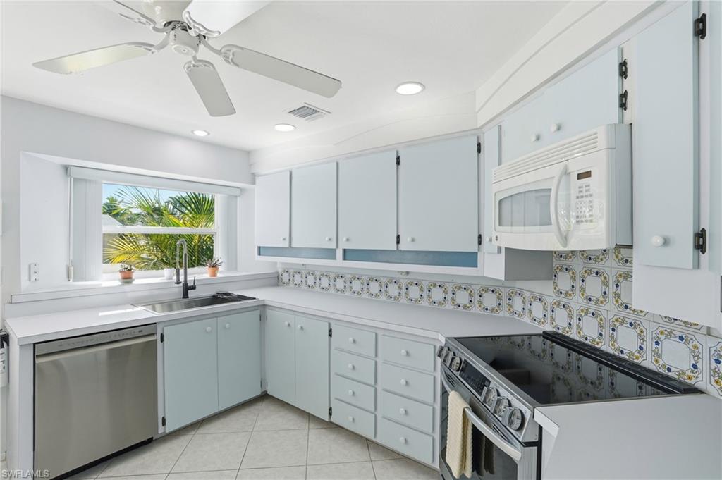 30 Maui Circle, Unit 30 Naples, FL 34112 - Photo 2 of 50 a kitchen with white cabinets a sink a stove and a window
