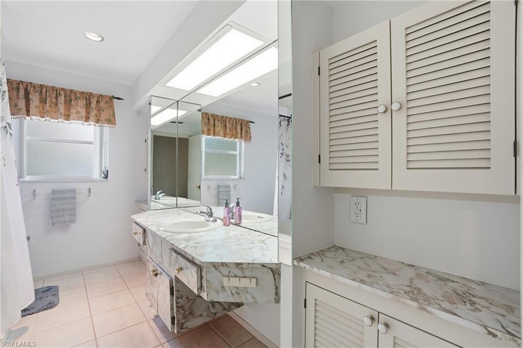 30 Maui Circle, Unit 30 Naples, FL 34112 - Photo 37 of 50 a bathroom with a granite countertop sink and a mirror