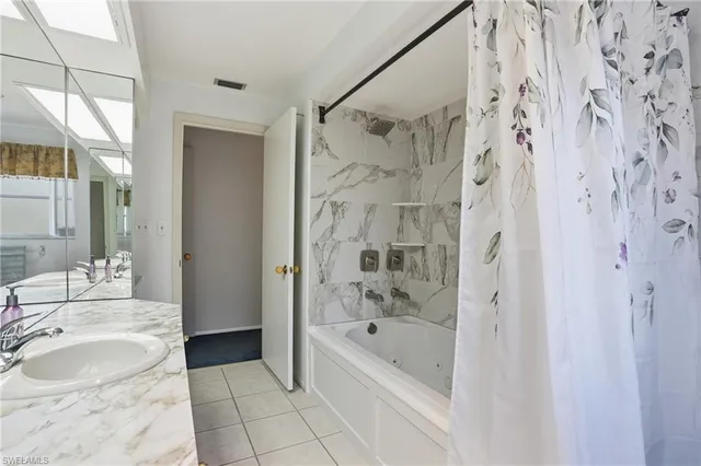 a bathroom with a granite countertop sink a mirror and a shower