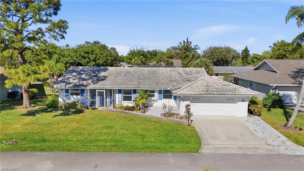 30 Maui Circle, Unit 30 Naples, FL 34112 - Photo 4 of 50 a front view of a house with a garden and trees