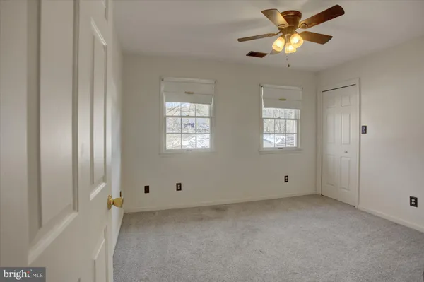 an empty room with closet and a window