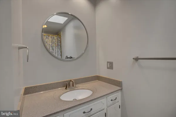 a bathroom with a granite countertop toilet sink and mirror