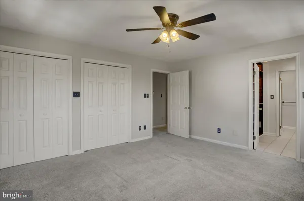 an empty room with wooden floor and a ceiling fan