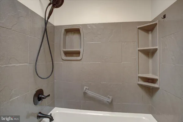 an empty room with wooden floor fireplace and windows