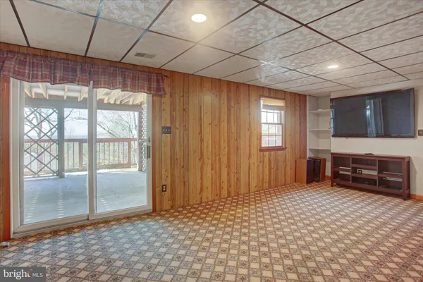 a view of wooden staircase with railing and white walls