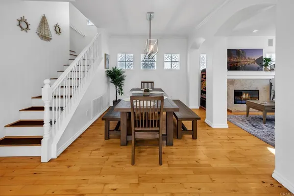 a view of a livingroom with furniture a fireplace a chandelier and wooden floor