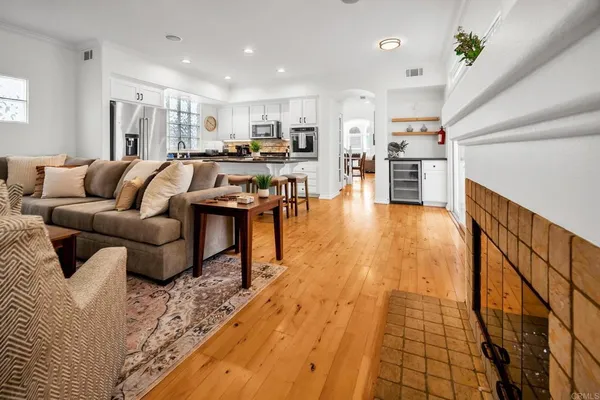 a living room with stainless steel appliances lots of furniture and kitchen view