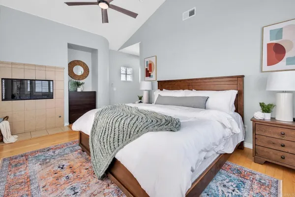 a bedroom with a bed and a lamp on dresser