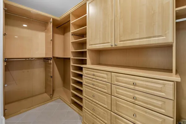 a view of walk in closet with empty racks
