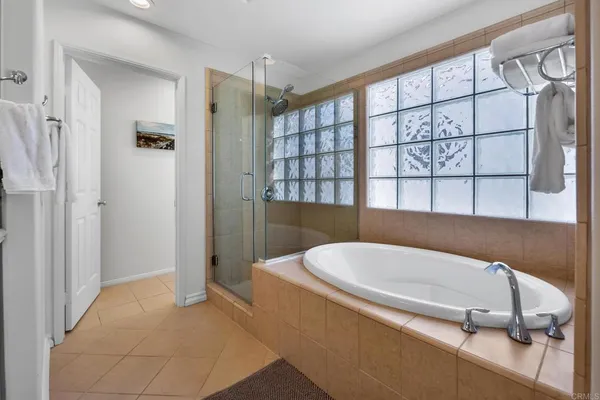 a bathroom with a tub a window and a shower