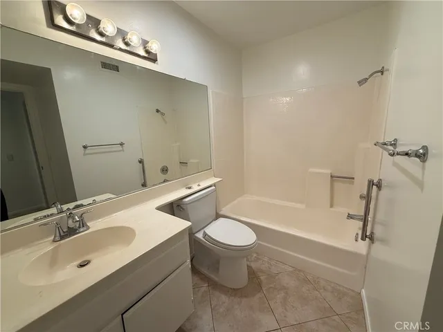 a bathroom with a toilet sink a mirror and shower
