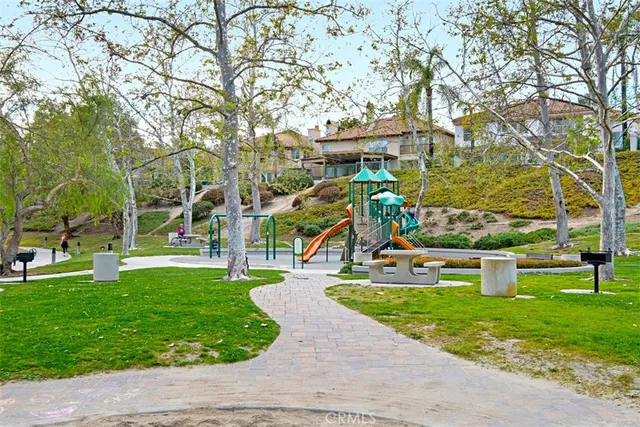 a view of a park with large trees and a wooden fence