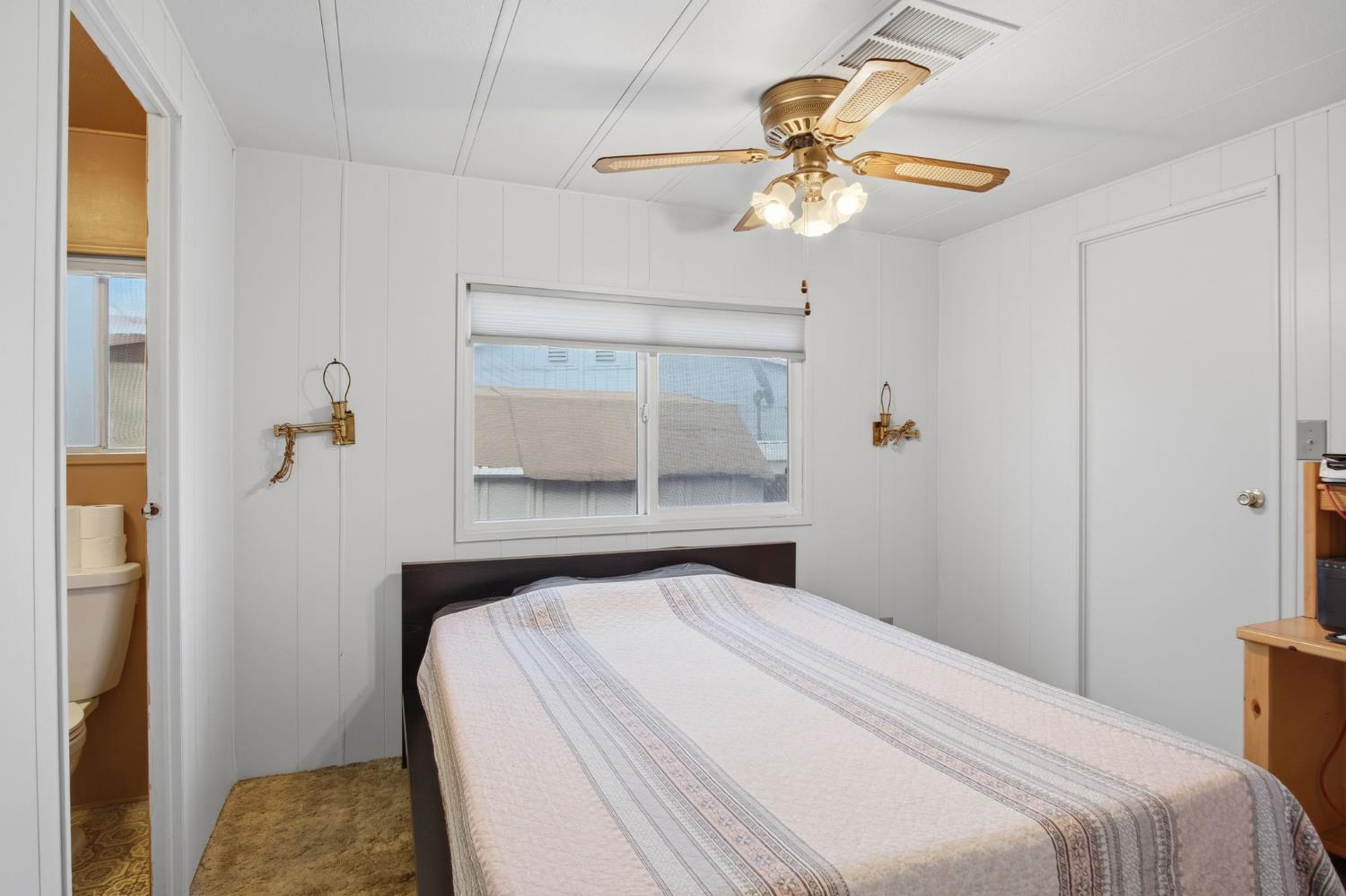 1400 Meredith Avenue, Unit 55 Gustine, CA 95322 - Photo 11 of 19 a bedroom with a bed and a chandelier